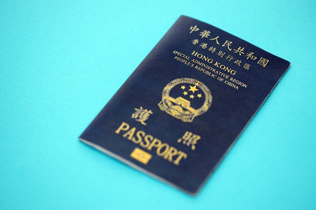 Hong Kong Special Administrative Region HKSAR Passport lies on blue table background close up. Hong...