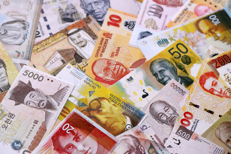 Various currencies money bills banknotes in yellow and orange color. Many cash bills from different...