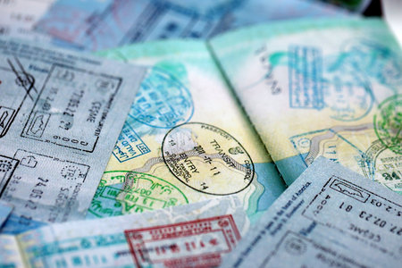 Big amount of passport pages full of colorful stamps after travel and border crossing. Tourism and border control concept. Immigration and travel around the worldの写真素材