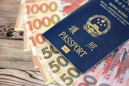 Hong Kong Special Administrative Region HKSAR Passport lies on flag with money bills banknotes close...