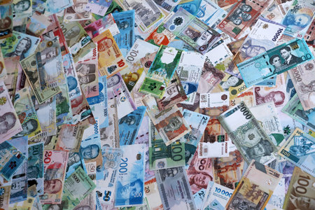 Different money banknotes from many currencies of the whole world. Big pile of money bills close up