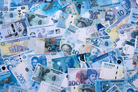 Various currencies money bills banknotes in full frame. Many cash bills from different countries in big pile close up. World economy and currency exchange conceptの写真素材