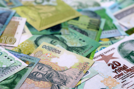 Various currencies money bills banknotes in green color. Many cash bills from different countries in big pile close up. World economy and currency exchange conceptの写真素材