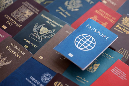 Fictional passport book travel document on big amount of real passport covers of various different...