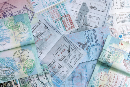 Big amount of passport pages full of colorful stamps after travel and border crossing. Tourism and border control concept. Immigration and travel around the worldの写真素材