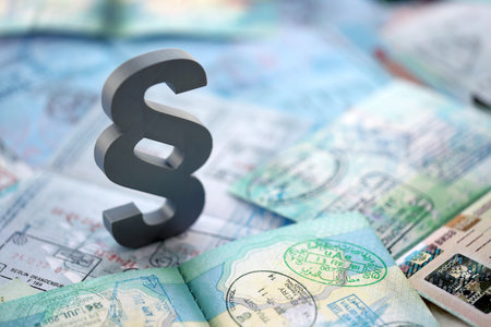 Paragraph symbol on passport pages full of colorful stamps after travel and tourism. Border control...