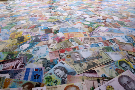 Different colorful banknotes from many various currencies of the world. Big stack of money bills on...