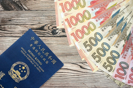 Hong Kong Special Administrative Region HKSAR Passport lies on flag with money bills banknotes close...