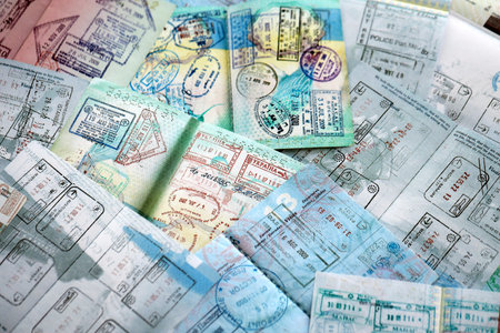 Big amount of passport pages full of colorful stamps after travel and border crossing. Tourism and...
