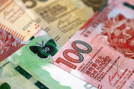 Big pile of Hong Kong dollars money bills banknotes close up. Lots of money of Chinese Hong Kong HKD...