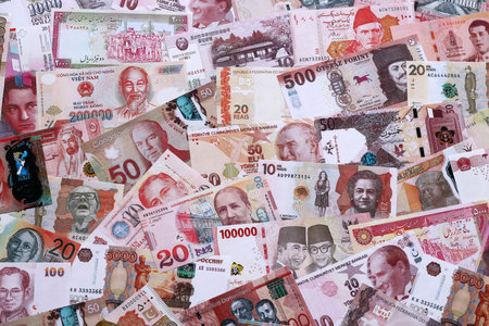 Various currencies money bills banknotes in red color. Many cash bills from different countries in...