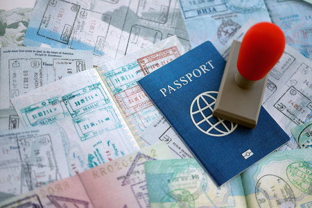 Border crossing stamp on passport pages full of colorful stamps after travel and tourism. Border...