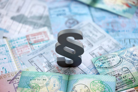 Paragraph symbol on passport pages full of colorful stamps after travel and tourism. Border control...