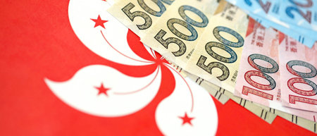 Big pile of Hong Kong dollars money bills banknotes on red flag. Lots of money of Chinese Hong Kong...