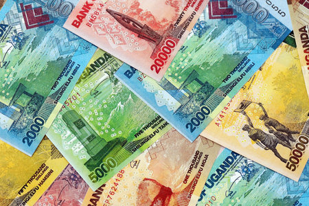 Ugandan shilling paper banknotes pile on table. Uganda UGX currency money bills in big amount....