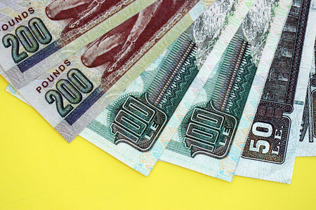Egyptian pound money bills in big amount on yellow close up. Finance and banking concept