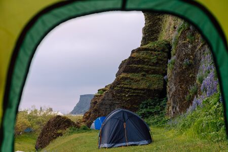 Inside a tent next to cliff with other tents
