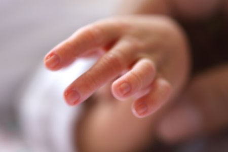 Baby holding mother's finger