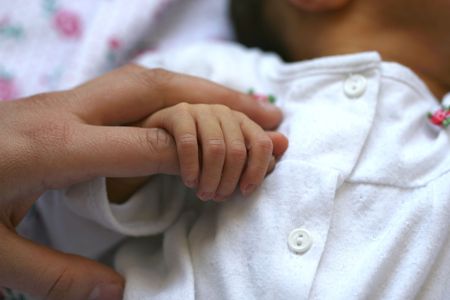 Baby holding mother's finger