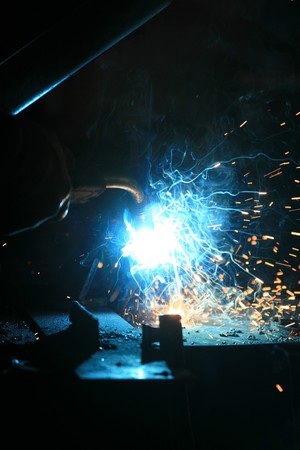A welder working with sparks flying around 