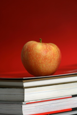 red apple resting on the book with chalk board as background の写真素材