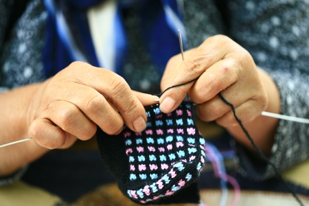 Hands of a young woman knitting with color wool の写真素材
