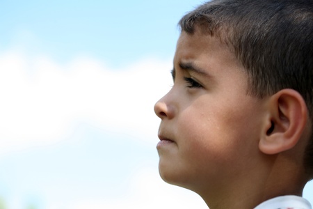 A sad little boy on a blue background の写真素材