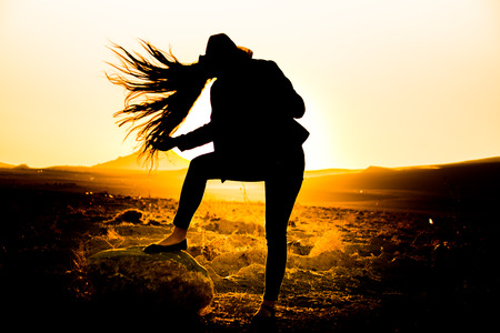 A beautiful woman silhouette at sunsetの写真素材