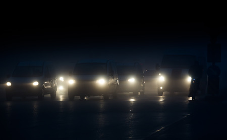 Headlights of cars driving in fog at nightの写真素材