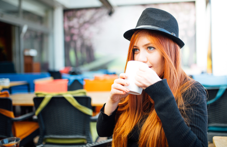 Beautiful girl drinking coffee at the coffee shopの写真素材