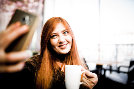 Beautiful girl drinking coffee at the coffee shopの写真素材