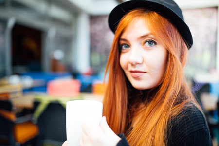 Beautiful girl drinking coffee at the coffee shopの写真素材