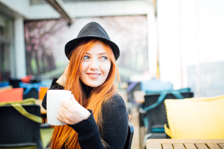 Beautiful girl drinking coffee at the coffee shopの写真素材