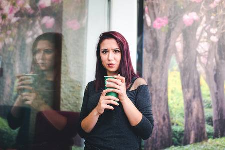 Beautiful girl drinking coffee at the coffee shopの写真素材