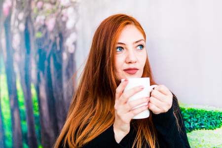 Beautiful girl drinking coffee at the coffee shopの写真素材