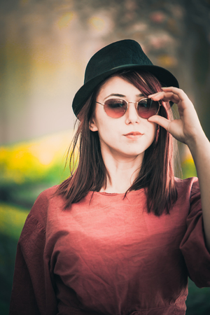 A beautiful girl wearing sunglasses and a hat posingの写真素材