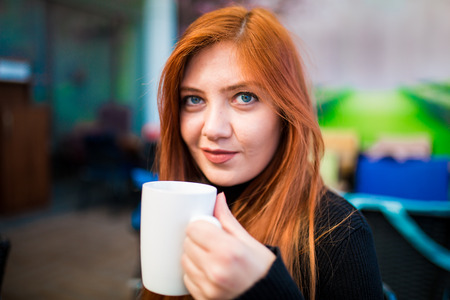 Beautiful girl drinking coffee at the coffee shopの写真素材