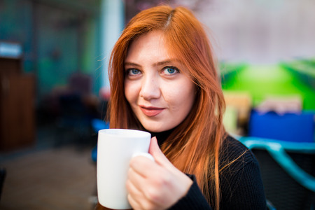 Beautiful girl drinking coffee at the coffee shop