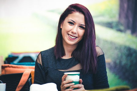 Beautiful girl drinking coffee at the coffee shopの写真素材