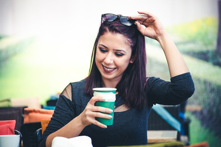 Beautiful girl drinking coffee at the coffee shopの写真素材