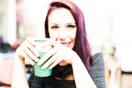 Beautiful girl drinking coffee at the coffee shopの写真素材