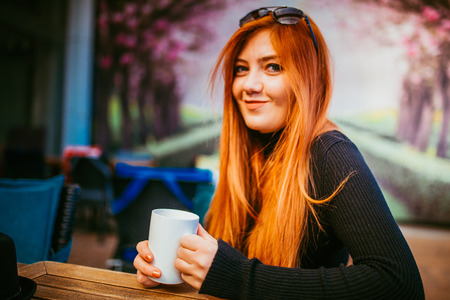 Beautiful girl drinking coffee at the coffee shopの写真素材