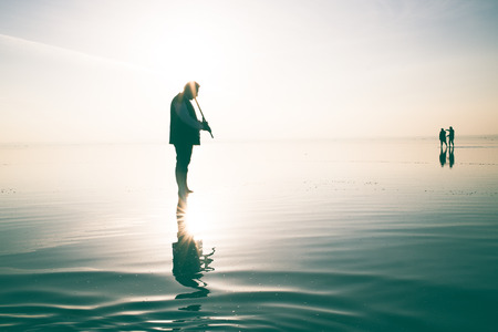 Silhouette people during sunset and photo shoot in salt lakeの写真素材