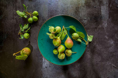pears on the plate on an aged tableの写真素材