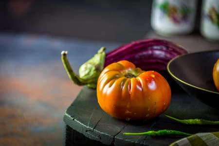 Preparation with vegetables on dark ground in the kitchen