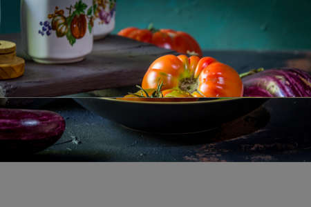 Preparation with vegetables on dark ground in the kitchenの写真素材