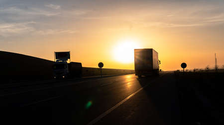 Truck driving on the highway at sunset. Freight transportation concept.の写真素材
