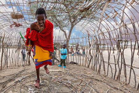 Samburu, Kenya - June 25, 2019: Samburu man walking in the house under construction.のeditorial素材