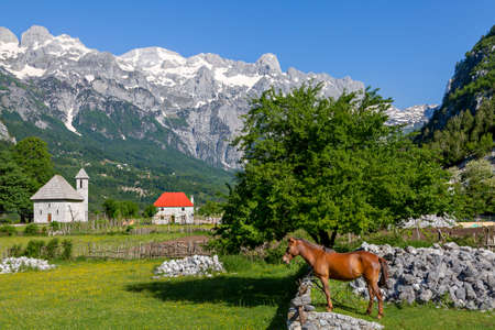 Theth Village and snow capped mountains in Thethi Valley, Albaniaの写真素材