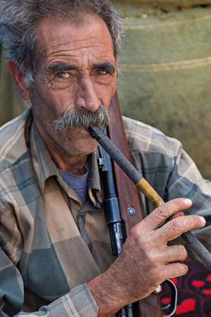 Iranian nomadic man belonging to the tribe known as Qashqai, smoking his pipe, in Firuzabad, Iran.